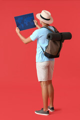 Male tourist with map on color background