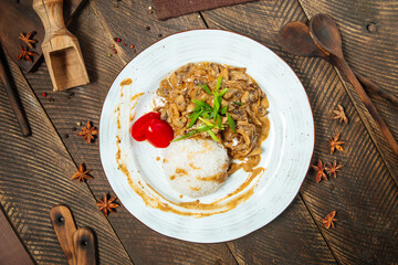 Wall Mural - On beef stroganoff with rice on a wooden table