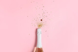 Fototapeta Panele - Bottle of champagne and glitters on color background. New Year celebration