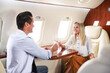 © New Africa - Couple clinking glasses of champagne during flight