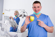 © JackF - Smiling male professional dentist posing at dental clinic with fresh yellow apple in hands