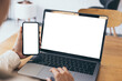 © panitan - computer,cell phone mockup.hand woman work using laptop texting mobile.blank screen with white background for advertising,contact business search information on desk in cafe.marketing,design