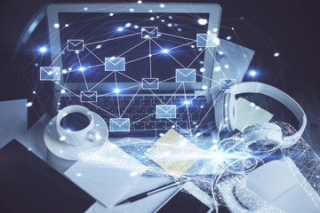 Desktop computer background in office and flying envelops hologram drawing. Double exposure. Electronic mail concept.