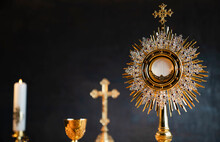 Catholic Religion Concept. Catholic Symbols Composition. The Cross, Monstrance,  Holy Bible And Golden Chalice On Wooden Altar. 