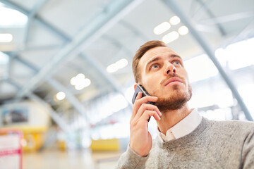 Wall Mural - Reisender telefoniert mit Smartphone im Flughafen