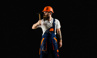 Wall Mural - Hammer hammering. Builder in helmet, hammer, handyman, builders in hardhat. Copy space. Bearded builder isolated on black background. Bearded man worker with beard, building helmet, hard hat