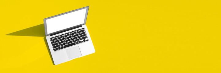modern laptop computer on the tabl on the color background