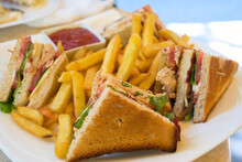A Club Sandwich (clubhouse Sandwich) Is A Sandwich Of Toasted Bread, Sliced Cooked Chicken Or Turkey, Ham Or Fried Bacon, Lettuce, Tomato, And Mayonnaise. It Is Served With French Fries.
