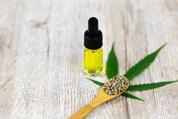 Hemp oil in glass bottles and seeds in wooden spoons, idea of ​​using hemp oil extracted to treat disease Alternative herbal medicine CBD. Alternative medicine treatment.