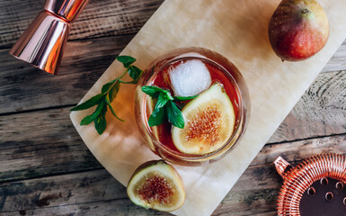 Wall Mural - Cold lemonade cocktail with figs on rustic wooden background