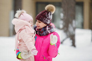 Mom and daughter in a snowy park.