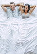 © My Ocean studio - Bedtime. The family are sleeping. Beautiful young couple in love are lying on the big white bed and resting. Husband and wife together in bed. Top view photo