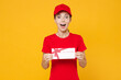 © ViDi Studio - Delivery employee woman in red cap blank t-shirt uniform work courier in service during quarantine coronavirus covid-19 virus, holding gift certificate isolated on yellow background studio portrait.
