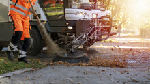 New Generation Of Small Electric Street Sweeper Removing Fallen Leaves In Body At Autumn City Park. Municipal Urban Services Using Ecology Green Vehicle Lorry To Clean Streets From Foliage.