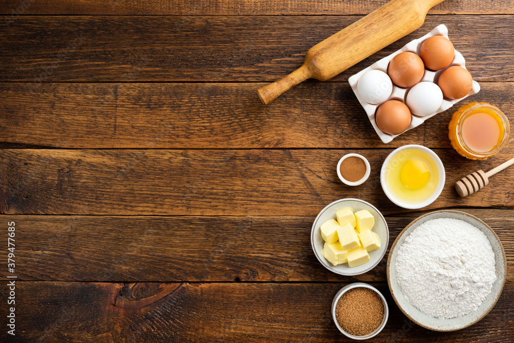 Cooking baking ingredients on a wooden table background. Flour