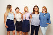 © Miljan Živković - Five women standing on front of white wall looking to the camera smile as a team - Front view group of people indoor studio shot business concept