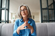 © insta_photos - Mature 60s old woman online teacher, remote tutor, distance coach therapist businesswoman talking to web cam virtual counseling conference video calling at home office. Headshot portrait. Webcam view.