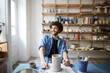 © Maskot - Smiling mid adult man looking away while sitting in pottery class