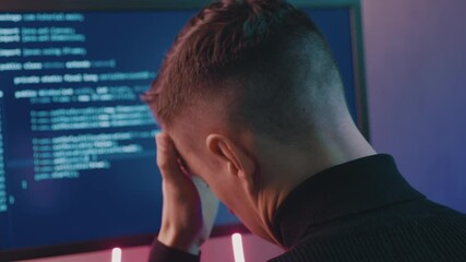 Rear view of developer having stress in the office. Man programmer has a headache at office work. Overworking concept.