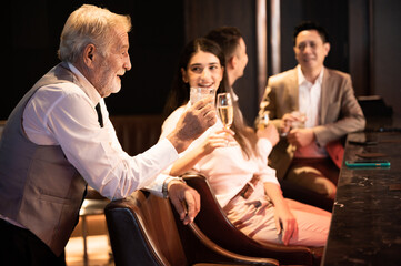 Cheers! Group of people cheering with champagne flutes in pub interior background