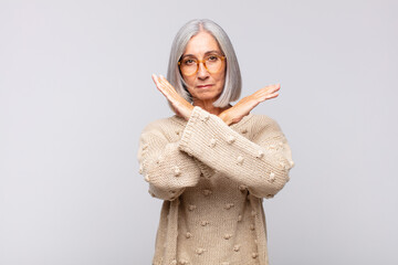 Wall Mural - gray haired woman looking annoyed and sick of your attitude, saying enough! hands crossed up front, telling you to stop