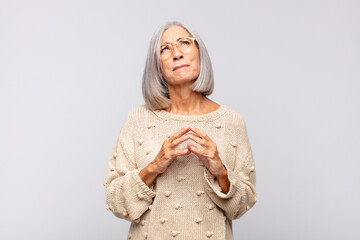 Wall Mural - gray haired woman scheming and conspiring, thinking devious tricks and cheats, cunning and betraying