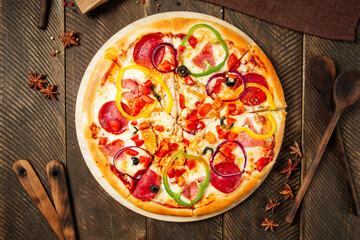Wall Mural - Pizza with salami and bell pepper on wooden table