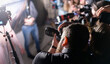 © Sergei Tim - Professional photographers photograph a person. The concept of a photo session, press conference. Selective focus.