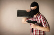 © Voyagerix - Man in balaclava holding keyboard and gun
