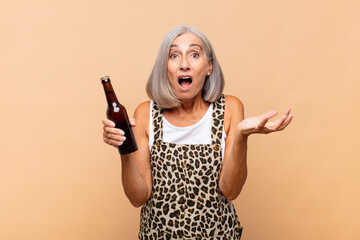 middle age woman feeling extremely shocked and surprised, anxious and panicking, with a stressed and horrified look with a beer