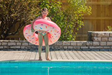 Sticker - cute young girl playing in the pool with her inflatable donut