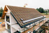 Fototapeta  - laying tiles on the roof of a single-family house