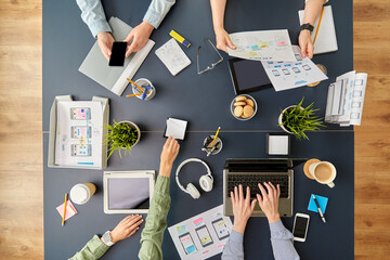 Wall Mural - business, people and team work concept - team of startuppers with gadgets and papers working at offi
