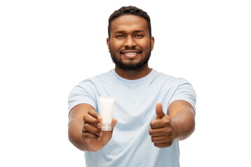 Wall Mural - grooming, skin care and people concept - happy smiling african american with moisturizer showing thumbs up over white background