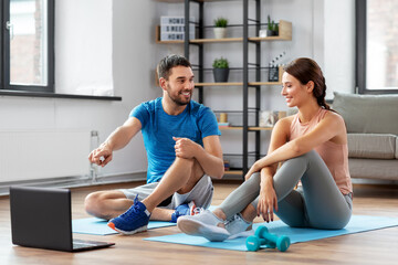 Wall Mural - fitness, sport and technology concept - happy couple with laptop computer doing sports at home