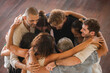 Diverse group of multiethnic people embracing and giving hugs to each other stayingin circle. Support, friendship and people connection