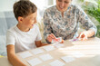 © skif - 7-year-old boy plays a memory Board game with his mother to develop memory