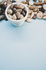 Sticker - Vertical shot of a bowl and small rocks on a blue surface