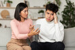 © Prostock-studio - Jealous Korean Wife Showing Cheating Husband His Smartphone At Home