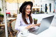 © F8  \ Suport Ukraine - Business woman using laptop at cafe. Young beautiful woman sitting in a coffee shop and working on computer