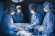 Group of surgeon at work in operating theatre. Medical team performing operation.