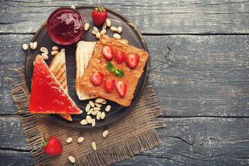 Poster - Bread with peanut butter, jam, fruits and nuts on grey wooden table