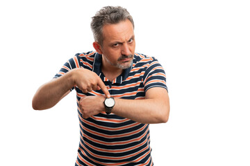 Angry male pointing index finger at wristwatch as time concept