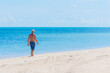 © Aleksandr Lavrinenko - man walk along the beach on the paradise island of koh samui in thailand, white beach and turquoise sea, palm trees and flags on the seashore, vacation in the tropics
