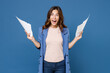 Excited screaming surprised shocked young brunette woman 20s wearing basic jacket hold papers document keeping mouth open looking camera isolated on bright blue colour wall background studio portrait.