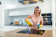 © Dusan Petkovic - Worthy cheerful housewife with rubber gloves spraying stove and cleaning it with sanitizer.