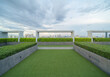 © tampatra - Sky garden on private rooftop of condominium or hotel, high rise architecture building with tree, grass field, and blue sky.