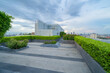 © tampatra - Sky garden on private rooftop of condominium or hotel, high rise architecture building with tree, grass field, and blue sky.