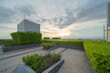 © tampatra - Sky garden on private rooftop of condominium or hotel, high rise architecture building with tree, grass field, and blue sky.