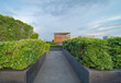 © tampatra - Sky garden on private rooftop of condominium or hotel, high rise architecture building with tree, grass field, and blue sky.